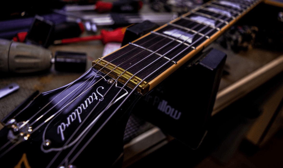 Guitarra eléctrica sobre la mesa de trabajo del taller